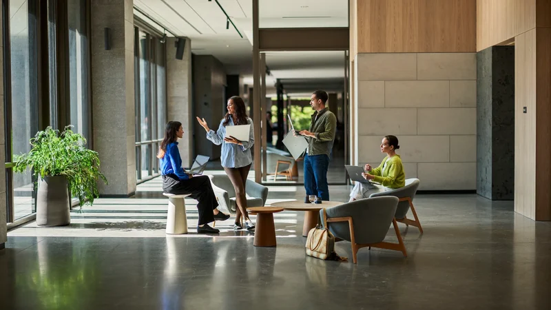 Studenti che conversano in una zona relax luminosa con portatili